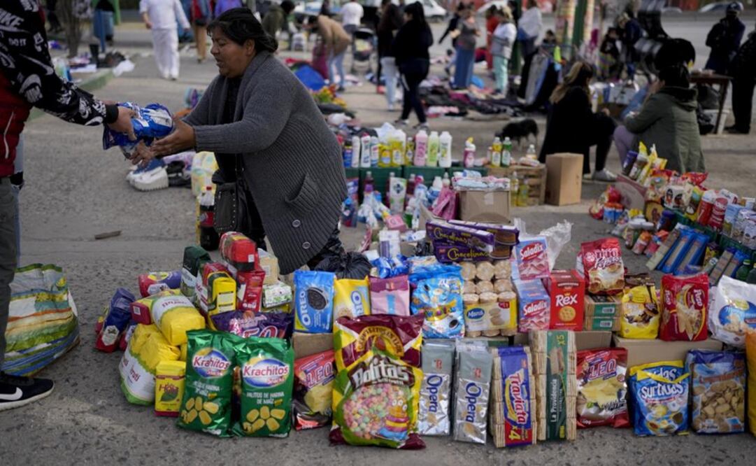 Prendas de segunda mano se exhiben en un tendedero improvisado en un mercado donde la gente puede comprar o intercambiar productos en las afueras de Buenos Aires. Foto: AP 