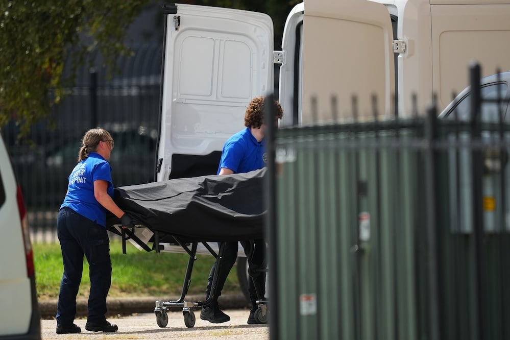 El cuerpo del hombre que disparó contra un centro de detención de migrantes del ICE en Dallas, Texas, es subido a una camioneta. FOTO: JULIO CORTEZ. AP