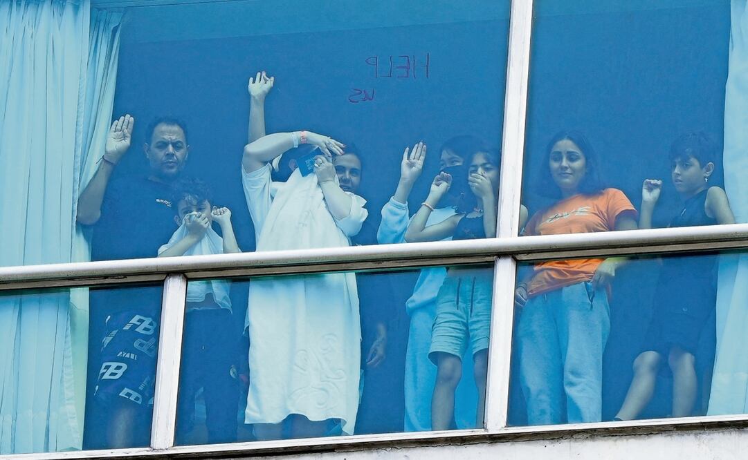 Migrantes deportados de Estados Unidos piden ayuda por la ventana del Hotel Decápolis, en la Ciudad de Panamá. Foto: Arnulfo Franco / AFP