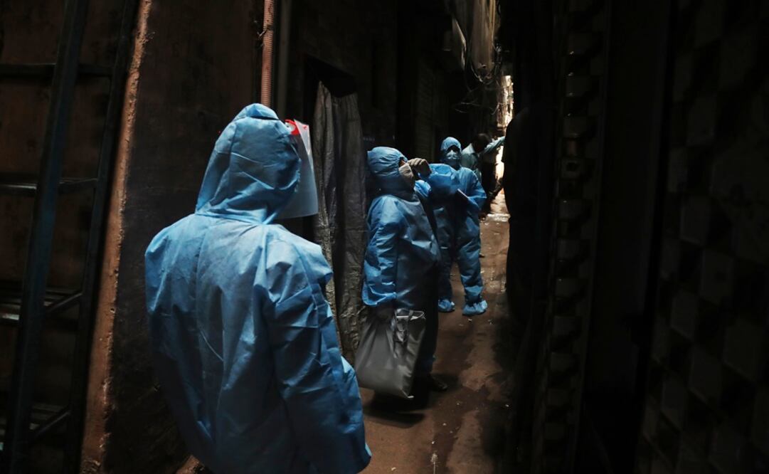 Health workers call people to come out for checking body temperature in Dharavi, one of Asia's largest slums, during lockdown to prevent the spread of the new coronavirus in Mumbai, India - Photo: Rafiq Maqbool/AP