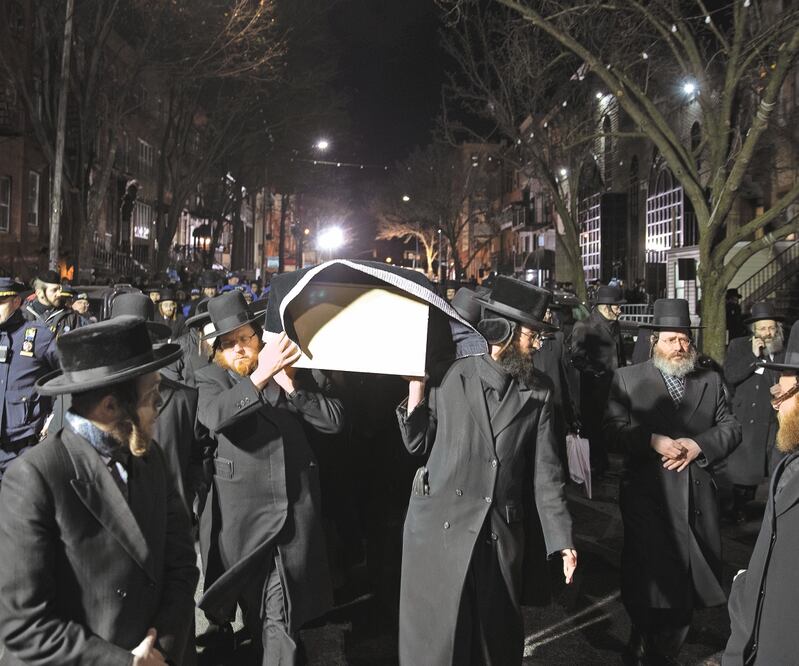 Judíos ortodoxos cargan, afuera de una sinagoga de Brooklyn, el féretro de una de las víctimas del tiroteo del martes pasado. MARK LENNIHAN. AP