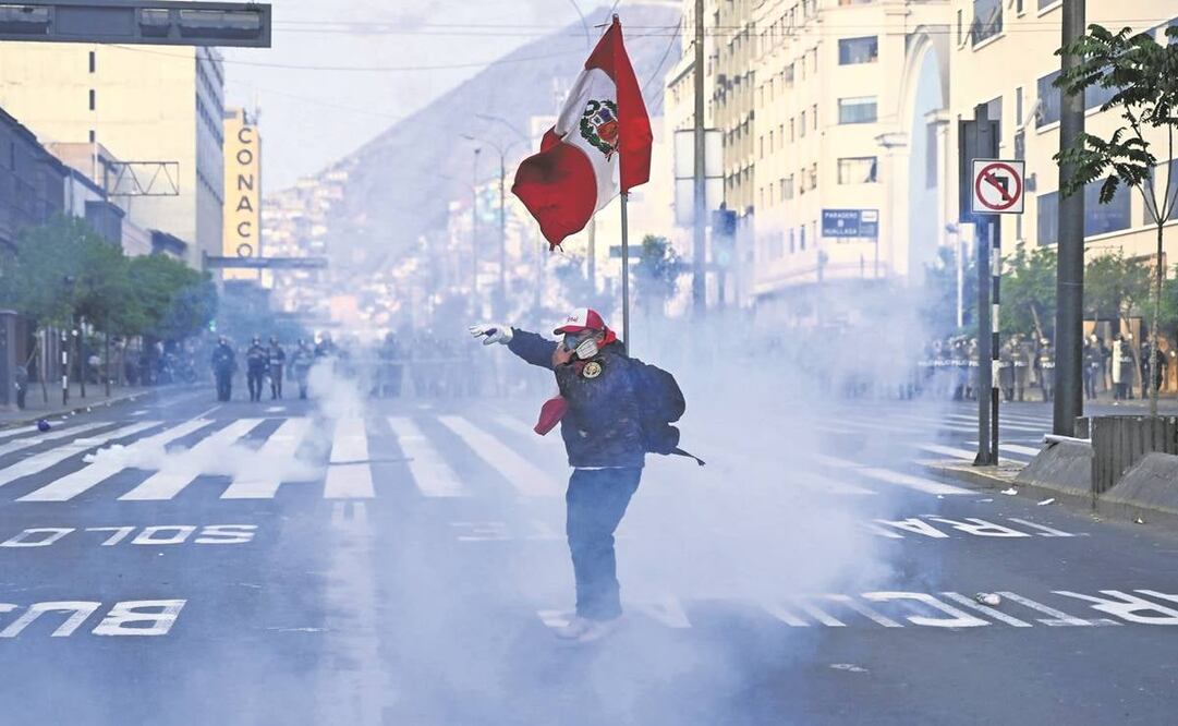 Un partidario del expresi- dente Castillo se protege del gas lacri-mógeno en una protesta, en Lima.Foto: Ernesto Benavides/AFP