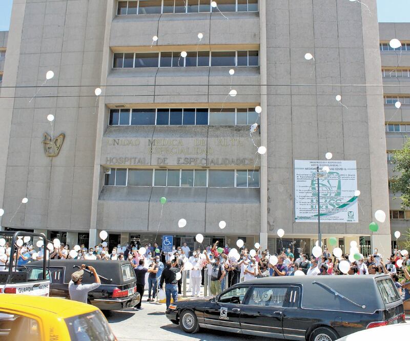Afuera de la Clínica 71 de Especialidades del IMSS, en Torreón, decenas de trabajadores esperaban el cortejo fúnebre que llevaría al panteón los cuerpos de sus compañeras Dora, Cecilia y Aracely, hermanas asesinadas el jueves. Foto: FRANCISCO RODRÍGUEZ