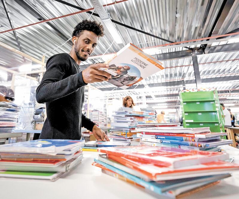 Un trabajador de vacaciones clasifica libros en Van Dijk Education en Kampen, Países Bajos, el 4 de agosto de 2020. Foto: ROBIN VAN LONKHUIJSEN. EFE