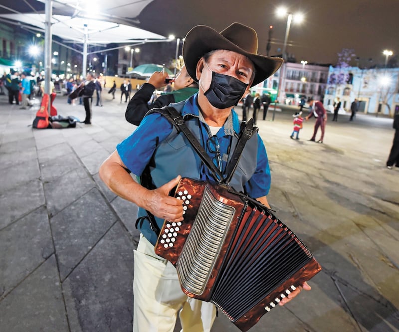 Un mariachi usa un cubrebocas mientras toca el acordeón buscando clientes en la plaza Garibaldi en la Ciudad de México, pese a la pandemia de coronavirus. Foto: ALFREDO ESTRELLA. AFP
