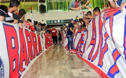 Cientos de seguidores reciben a Chivas en el AICM