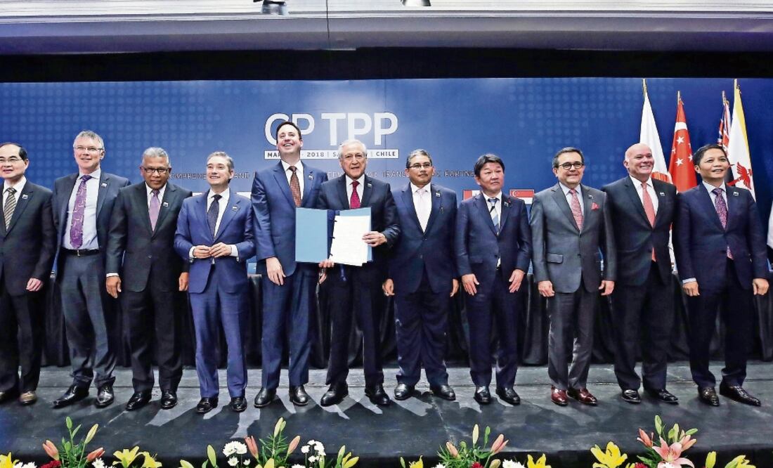 Los once ministros de Economía de los países integrantes del CPTPP, entre ellos Ildefonso Guajardo, de México, muestran el documento firmado ayer en Chile (MARIO RUIZ. EFE)