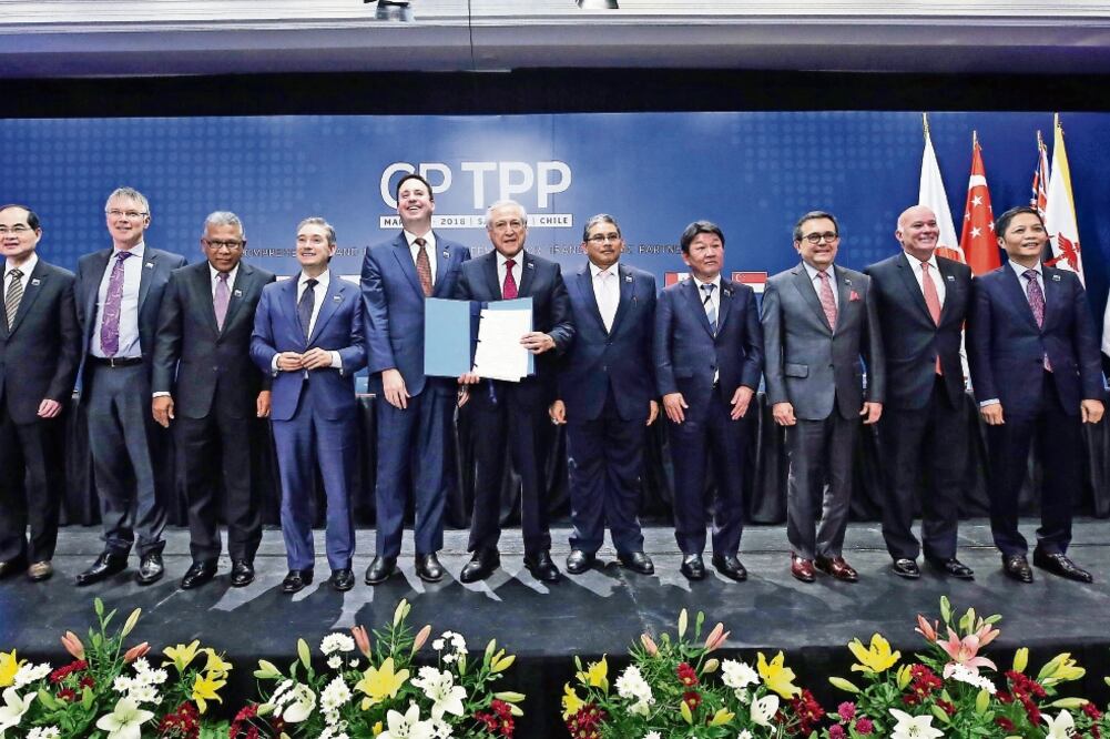 Los once ministros de Economía de los países integrantes del CPTPP, entre ellos Ildefonso Guajardo, de México, muestran el documento firmado ayer en Chile (MARIO RUIZ. EFE)