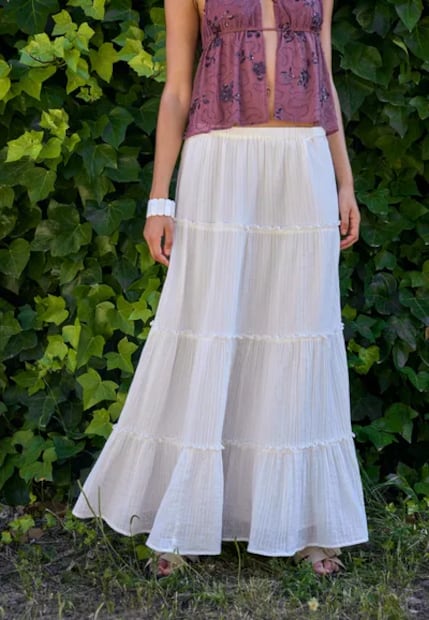 Falda midi fluida blanca con cintura elástica y forro interior combinado. Foto: Stradivarius