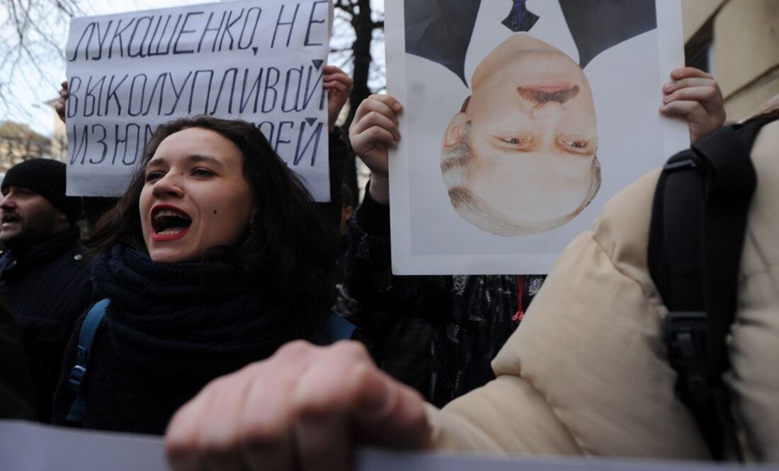 Belarusian opposition supporters with an upside down portrait of President Alexander Lukashenko taking part in a rally - Photo: Sergei Gapon/AFP