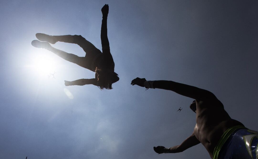 Lucha Libre wrestlers "El Sol," or The Sun, flies over "Gran Felipe Jr." or The Great Felipe Jr., during an exhibition fight for the media as they train for what will be live streaming events  - Photo: Marco Ugarte/AP