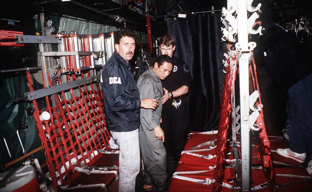 En un avión de la Fuerza Aérea de Estados Unidos, el general panameño Manuel Noriega (al centro de traje gris de preso) es custodiado en enero de 1990 por dos oficiales de la DEA, agencia antidroga estadounidense. Foto: Gobierno de Estados Unidos