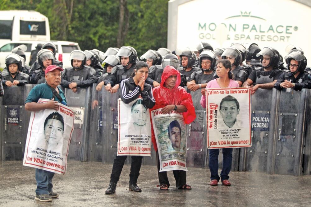 Buscan apoyo. Los familiares de los 43 normalistas de Ayotzinapa intentaron acercarse a los representantes de los Estados de la OEA reunidos en Cancún (ALONSO CUPUL. EFE)