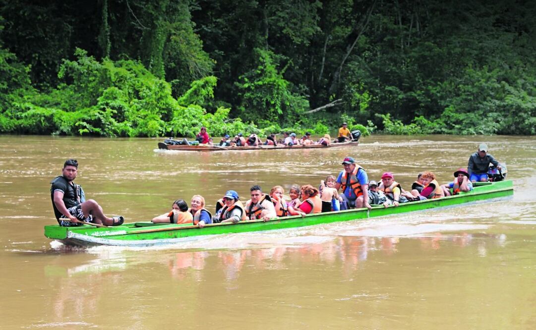Migrantes al llegar por el río Turquesa desde el poblado de Bajo Chiquito hasta el centro de recepción de Lajas Blancas, en el Darién. Foto: Moncho Torres | EFE