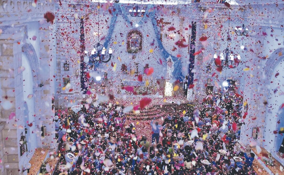 Unas 40 personas del pueblo suben a la cúpula de la iglesia de la Purísima Concepción para arrojar los pétalos que los asistentes recogen como recuerdo. Fotos Especiales