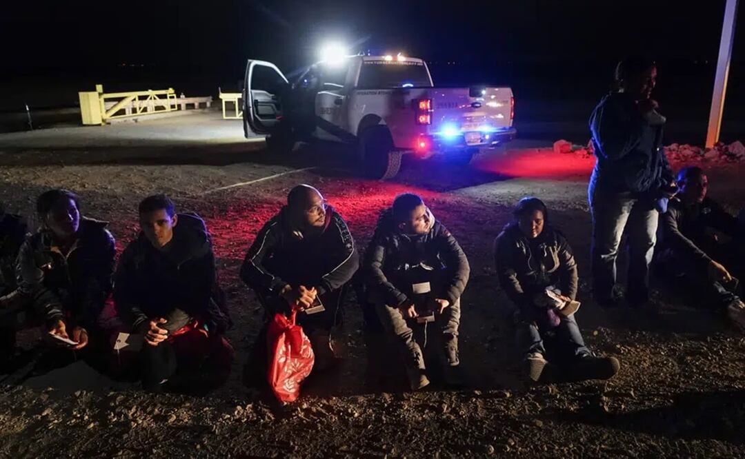 Varios migrantes esperan a ser procesados después de cruzar la frontera de México a Estados Unidos, cerca de Yuma, Arizona. Foto: AP