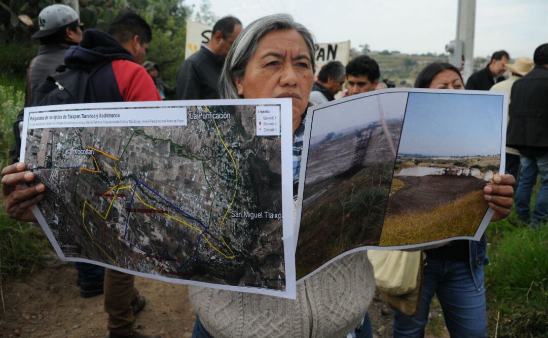 Una residente de las inmediaciones del sitio donde se construye el nuevo aeropuerto de Ciudad de México muestra planos durante una manifestación de oposición al proyecto. FOTO: EFE