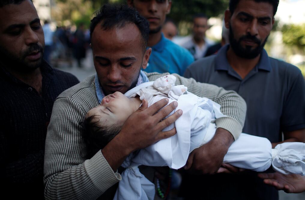 El padre de la bebé de ocho meses, Laila al-Ghandour la sostiene en sus brazos. Fortografía de Reuters