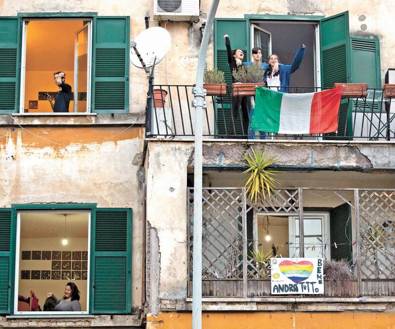 Italianos miran hacia la calle en el distrito Garbatella, en Roma, donde permanecen en cuarentena ante la expansión del coronavirus. MASSIMO PERCOSSI. EFE