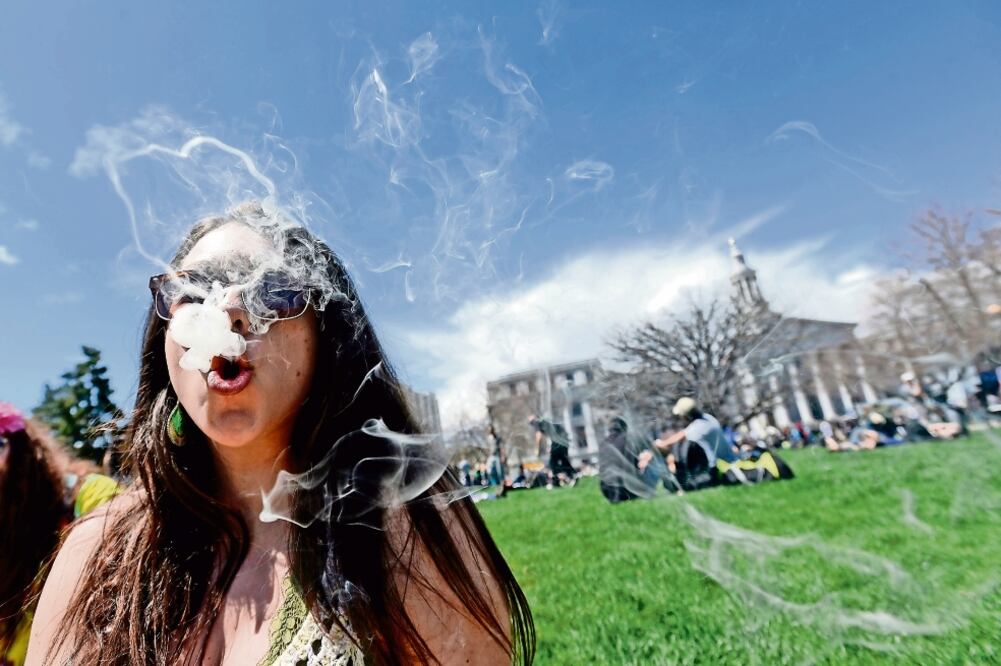 Una joven fuma marihuana en el Centro Cívico en Denver, en Colorado, en abril de 2014. Según WOLA, la droga seguirá siendo abundante en EU (ARCHIVO. REUTERS)