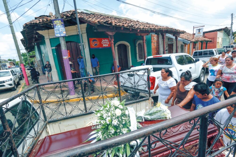 El cortejo fúnebre de Erick Jiménez López, de 15 años, pasa frente a milicianos armados del gobierno en el barrio Monimbó de Masaya, Nicaragua (ALFREDO ZUNIGA. AP)