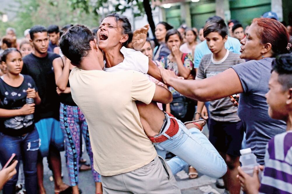 Familiares de detenidos en una estación policial en el estado de Carabobo reaccionan ante la falta de información de las autoridades venezolanas sobre el motín e incendio en los calabozos del lugar. (CARLOS GARCÍA RAWLINS. REUTERS)