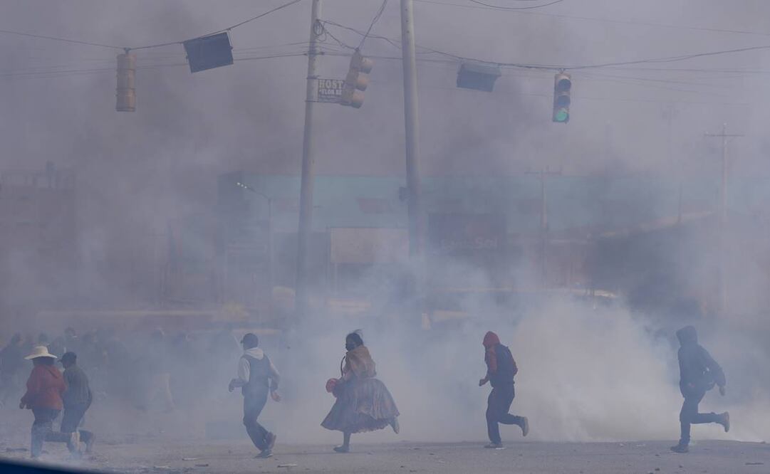 La gente corre entre gases lacrimógenos lanzados por la policía durante enfrentamientos entre partidarios del expresidente Evo Morales y el actual presidente Luis Arce el 22 de septiembre del 2024. Foto: AP