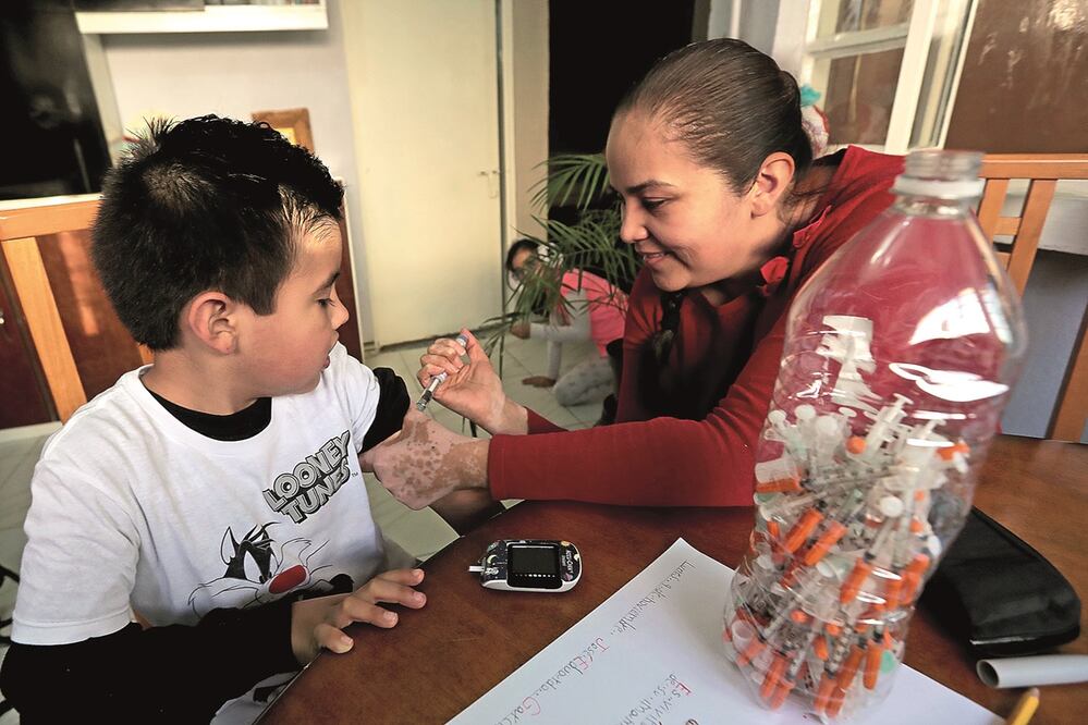 Francisca inyecta con insulina a su hijo de seis años, Eduardo, quien padece diabetes; ante la pandemia de Covid-19, ella y su esposo decidieron mantener al pequeño en casa, pues se encuentra entre la población vulnerable. Fotos: JUAN BOITES