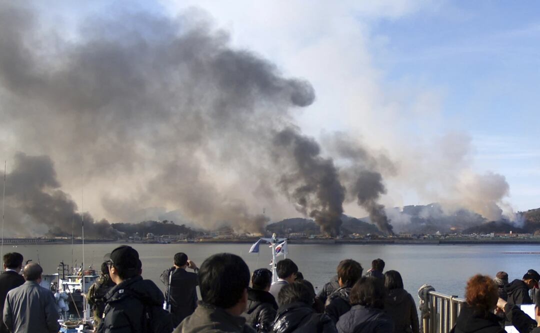 Surcoreanos observan las columnas de humo que se alzan en la isla de Yeonpyeong, en Corea del Sur, cerca de la frontera con Corea del Norte, el martes 23 de noviembre de 2010. Foto: AP