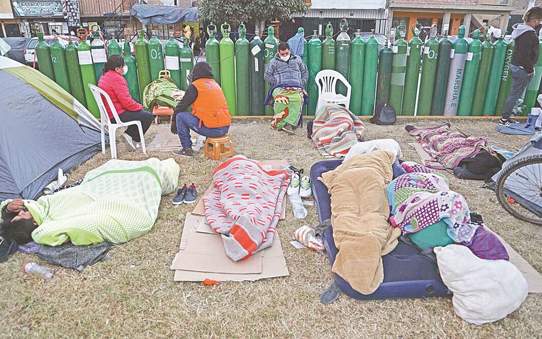 Peruanos acampan mientras abren los locales para rellenar los tanques de oxígeno en El Callao. MARTIN MEJIA. AP