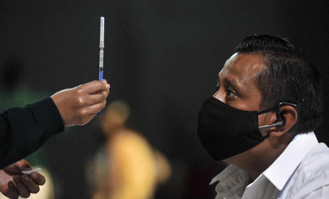 Trabajadora de la salud muestra a un hombre una dosis de una vacuna antiCovid. Foto: Xinhua