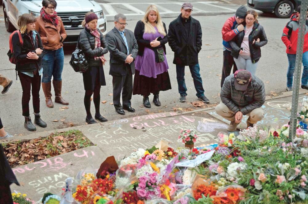 Ciudadanos de Pittsburgh dejan flores en un monumento conmemorativo a las víctimas del tiroteo masivo que mató a 11 personas en una sinagoga (JEFF SWENSEN. AFP)