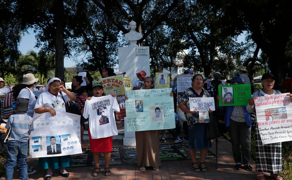 Personas sostienen carteles durante una marcha este domingo, en San Salvador, El Salvador. Foto: EFE