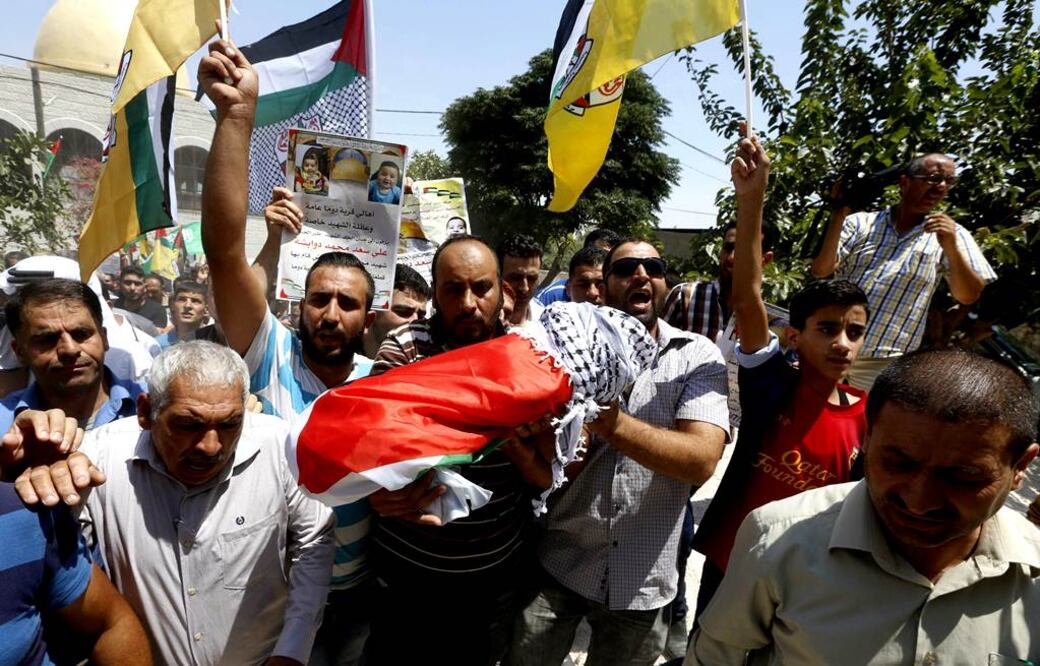 Un grupo de palestinos avanza con el cuerpo sin vida de Ali Dawabsha, de 18 meses de vida, durante su funeral en Nablus, Cisjordania. Foto EFE