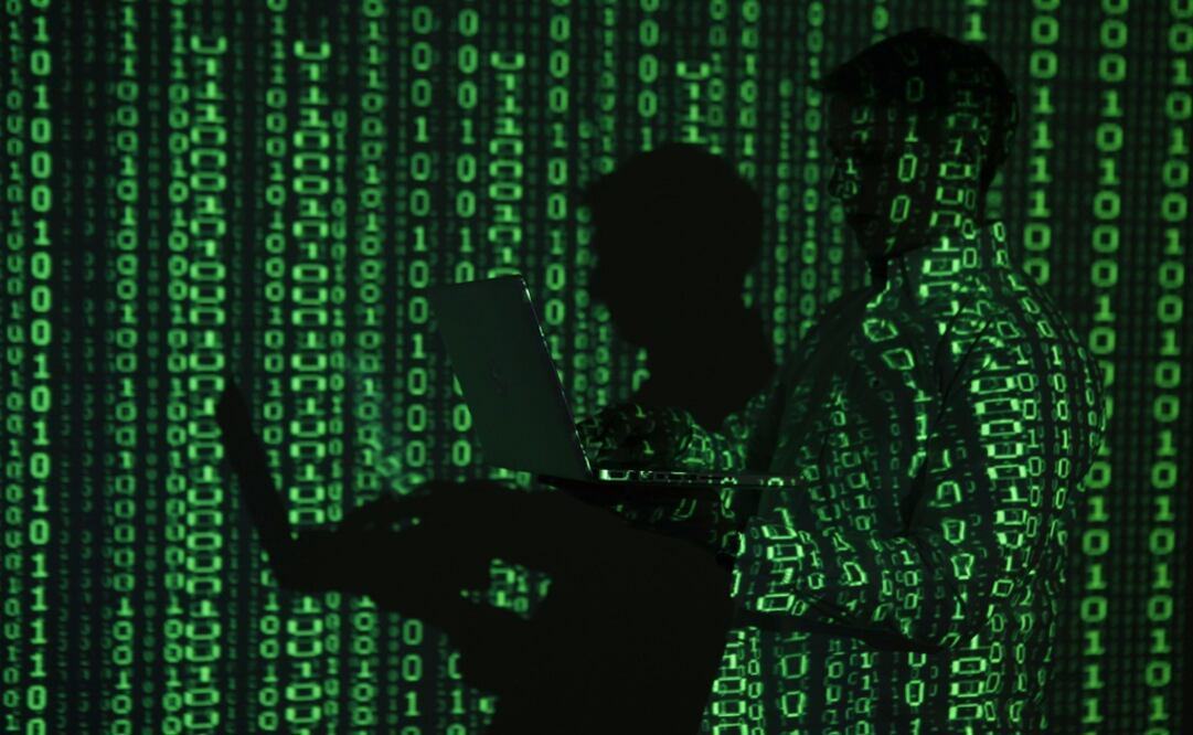 	A projection of binary code on a man holding a laptop computer – Photo: Kacper Pempel/REUTERS