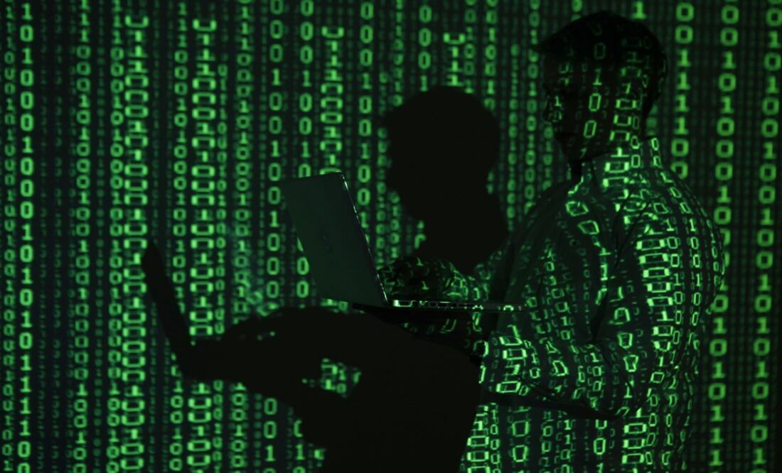 A projection of binary code on a man holding a laptop computer – Photo: Kacper Pempel/REUTERS