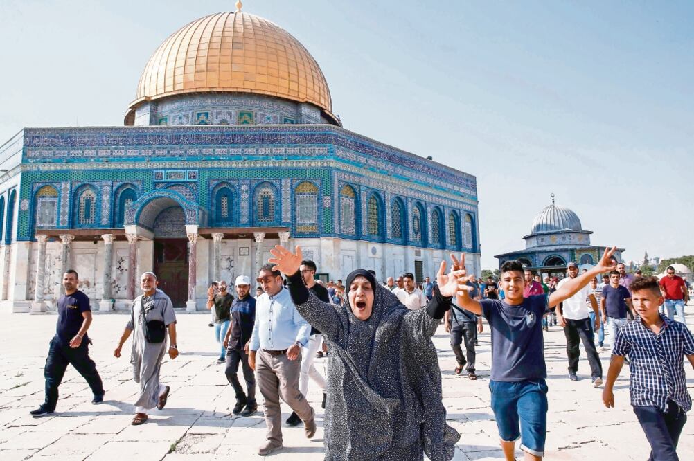 Musulmanes palestinos reaccionan tras ingresar al Monte del Templo, en la vieja ciudad de Jerusalén. Miles de fieles irrumpieron en el lugar luego de que Israel levantara las medidas de seguridad. (AHMAD GHARABLI. AFP)