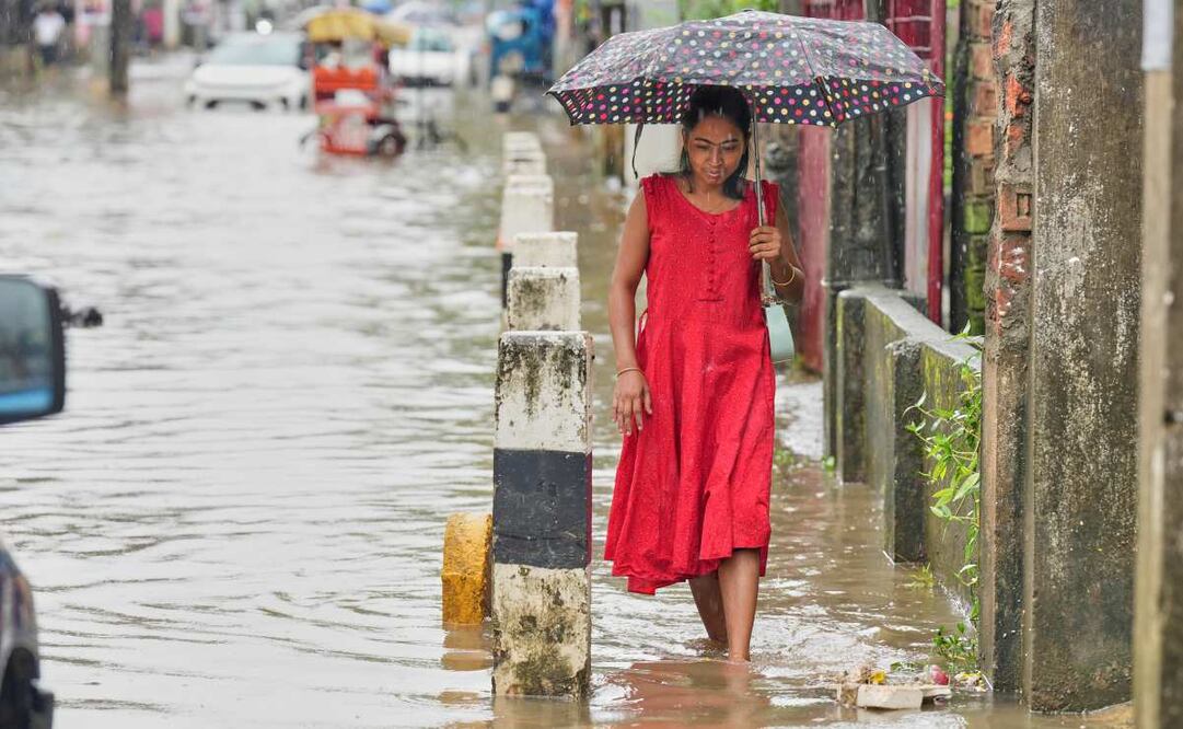 Una mujer camina por una calle inundada tras las fuertes lluvias monzónicas en Guwahati, en Assam, India, el miércoles 13 de agosto de 2025. Foto: AP