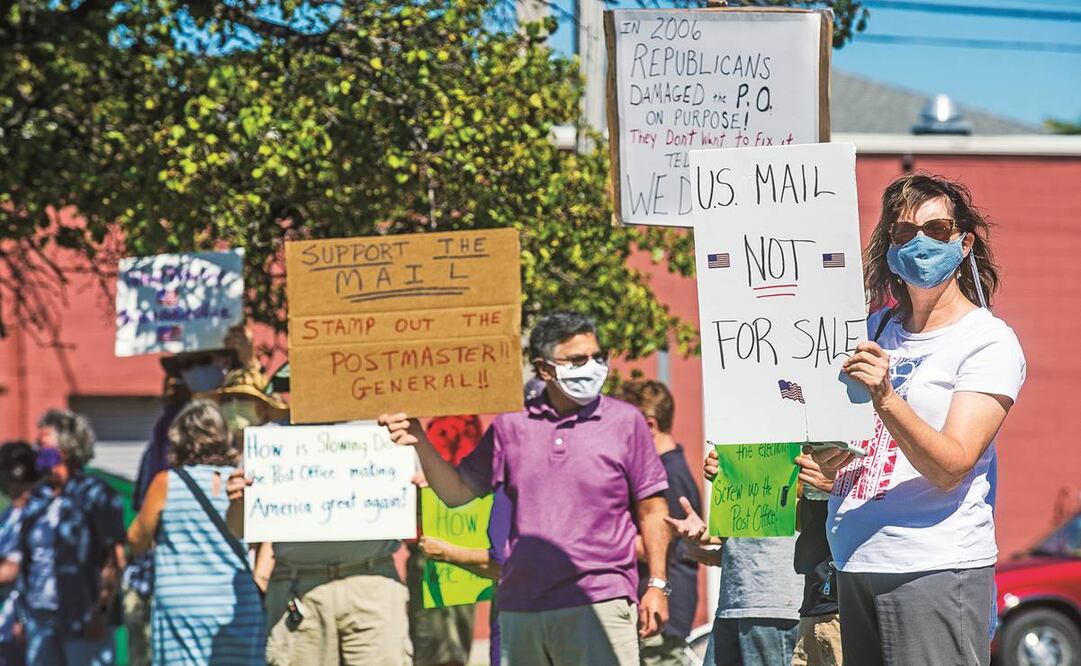 Frente al Servicio Postal de EU, en Midland, Michigan, manifestantes rechazaron nuevas medidas. Mientras aumenta la necesidad de entregar a tiempo el correo, el servicio ha sido restringido. Foto: AP