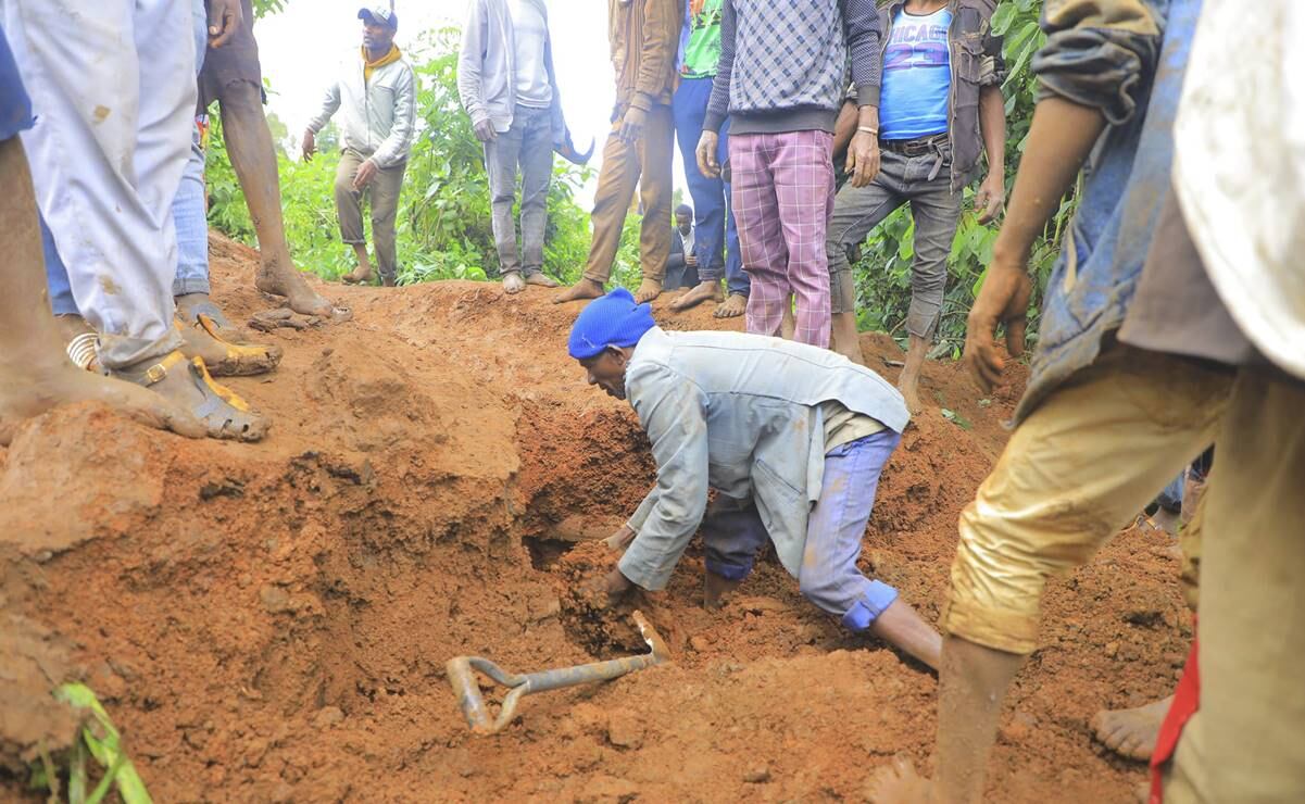 Hombre busca sobrevivientes mientras cientos de personas se congregan en el lugar donde se produjo un deslave. Foto: AP