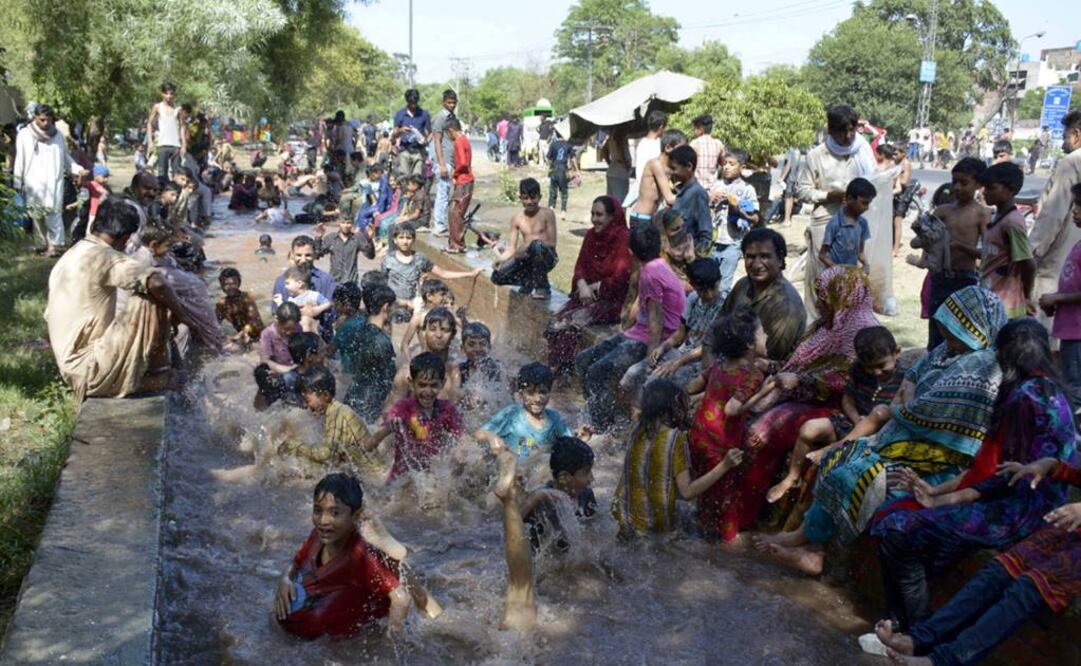 Personas se refrescan en un canal durante la ola de calor, en Lahore, en el este de Pakistán (Foto: Xinhua)