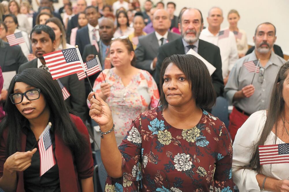 Ciudadana. Michele Gray, originaria de Jamaica (der.), durante una ceremonia de naturalización en Miami, EU. Foto: JOE RAEDLE. AFP
