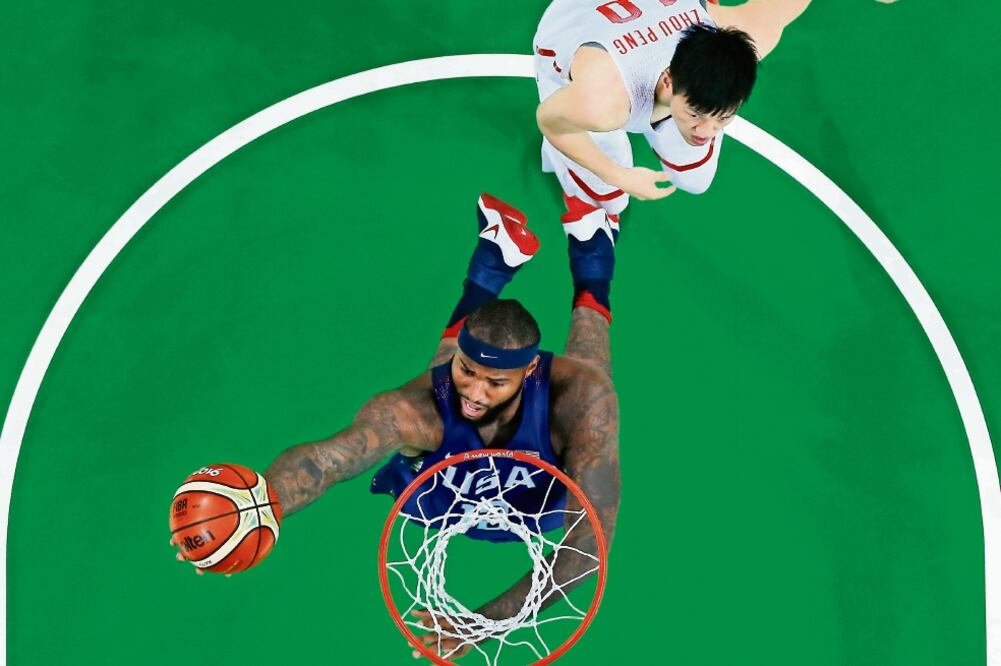 DeMarcus Cousins encesta ante la mirada del chino Zou Peng, aunque el mejor anotador de Estados Unidos fue Kevin Durant (JIM YOUNG. REUTERS)