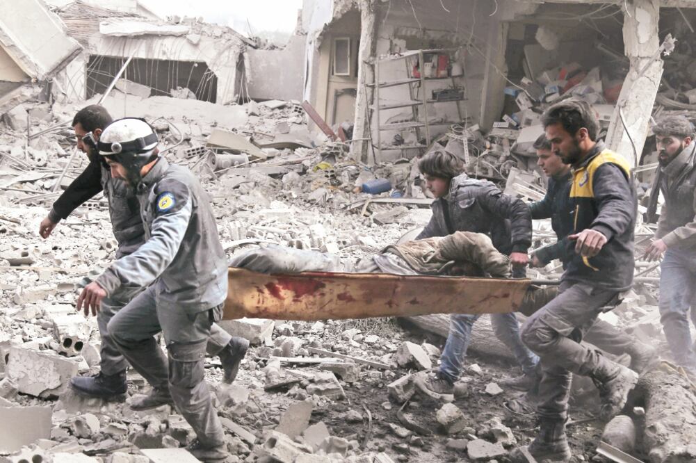 Sirios se llevan a un civil herido, tras un ataque aéreo de las fuerzas del régimen de Bashar al-Assad, ayer en Guta oriental (ABDULMONAM EASSA. AFP)