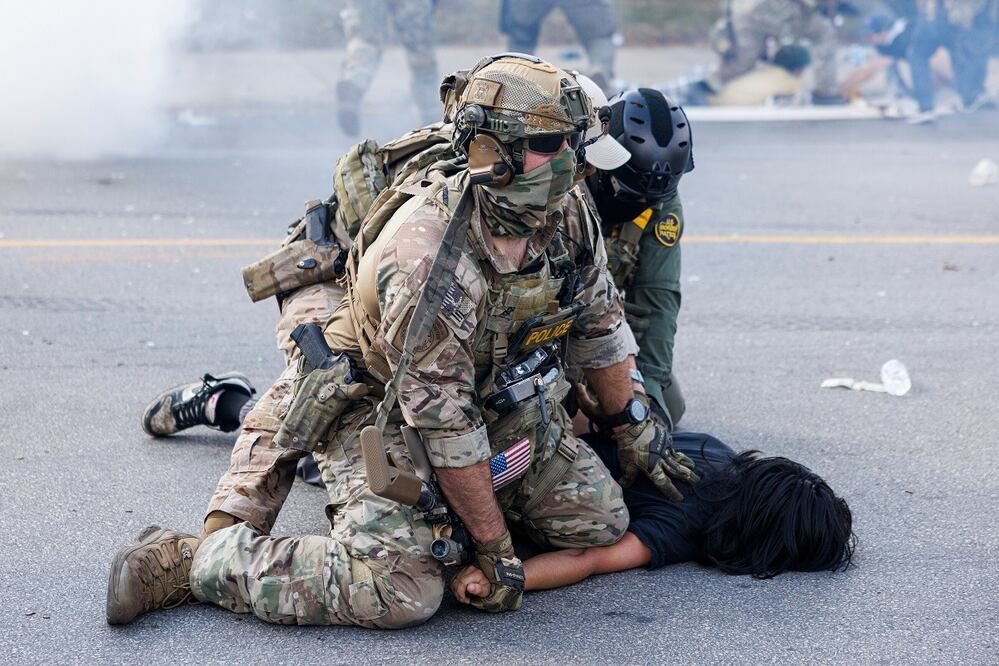 Agentes federales derriban a un manifestante en el vecindario de Brighton Park, en Chicago, desatadas tras el incidente en el que agentes de la Patrulla Fronteriza dispararon a una mujer en el sur de Chicago, el sábado. FOTO: AP