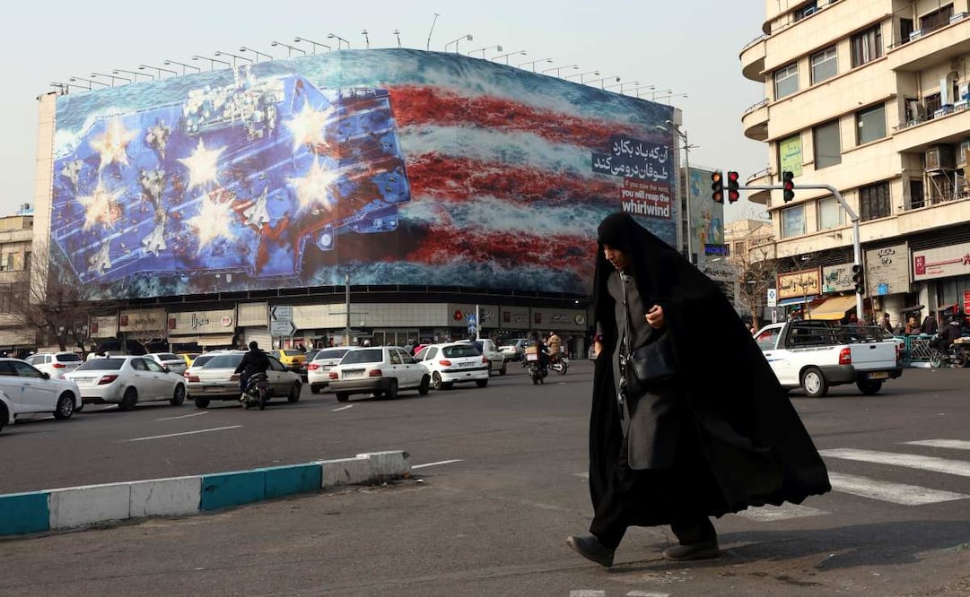 Una mujer con velo pasa junto a una gran valla publicitaria antiestadounidense en la plaza Enqelab de Teherán, Irán, el 25 de enero de 2026. El presidente estadounidense, Donald Trump, renovó sus amenazas de acción militar contra Irán tras las protestas antigubernamentales. Irán sufre un apagón nacional de internet que comenzó el 8 de enero de 2026, en medio de una creciente ola de protestas antigubernamentales. Foto: EFE