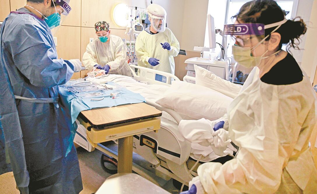 Empleados de la salud realizan una traqueotomía a un paciente con coronavirus en una unidad de cuidados intensivos en el Providence Holy Cross Medical Center, en Los Ángeles, California. Foto: MARIO TAMA. AFP