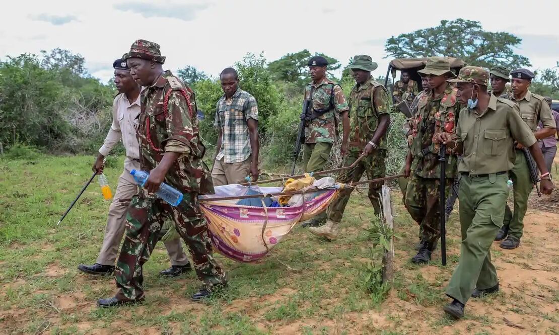Policías y residentes llevan los cuerpos exhumados de las víctimas del culto religioso de Paul Mackenzie Nthenge por el pueblo de Shakahola. FOTO:  AP