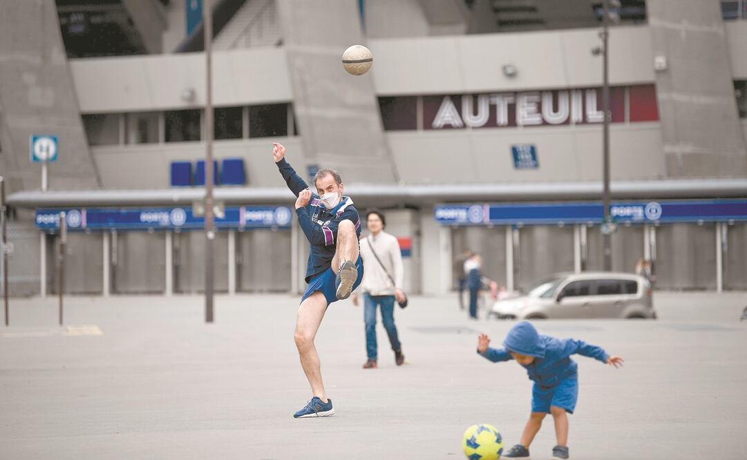 Un hombre juega futbol enfrente del Parque de los Príncipes, en París. El premier Edouard Philippe anunció la reapertura a partir del 11 de mayo de todos los comercios, excepto los restaurantes y cafés. Foto: FRANCK FIFE. AFP