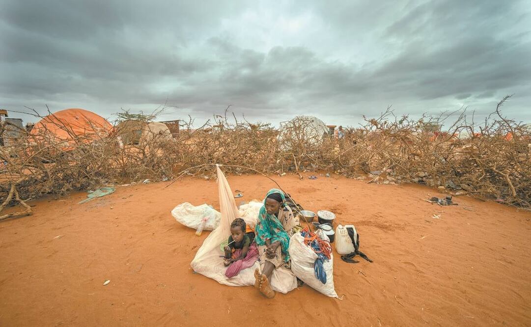 Una mujer y un niño esperan para instalarse en un campamento para desplazados en Somalia.